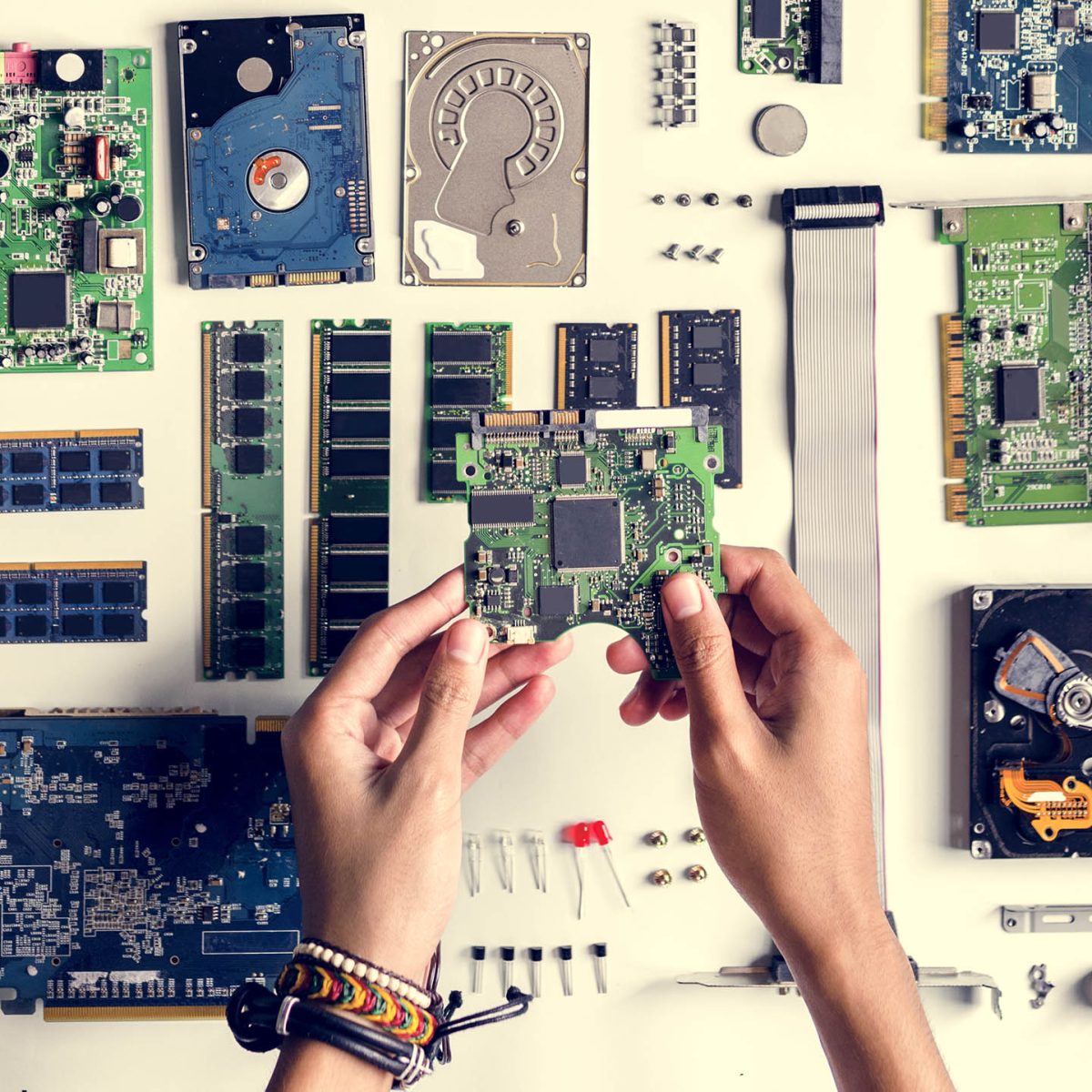 Aerial view of hands with computer electronics parts on white background
